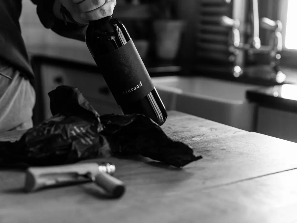 Unwrapping a bottle of Sieraad from black tissue