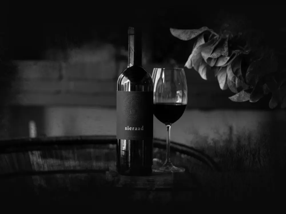 A bottle of Sieraad and glasses at an evening table