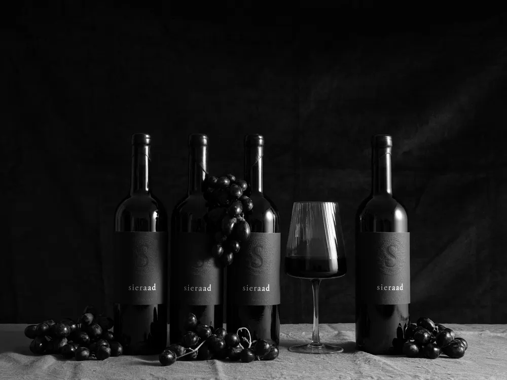 Sieraad bottles with grapes and a poured glass