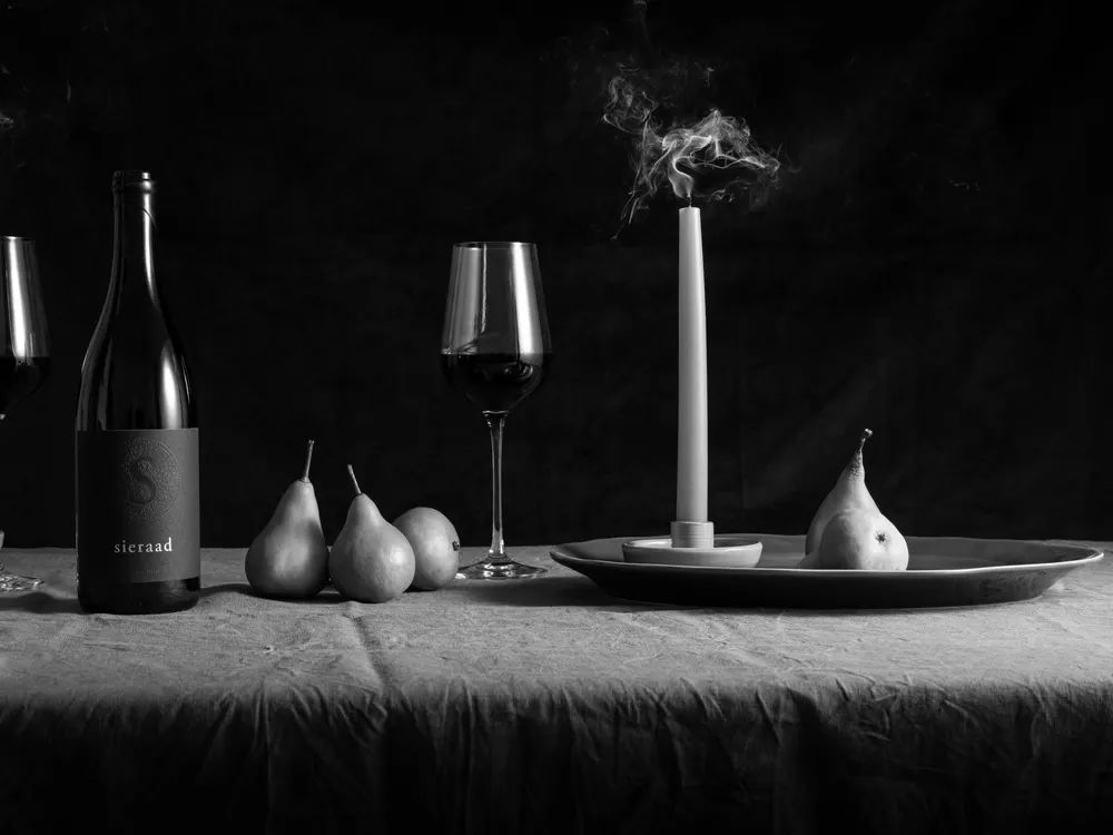 A shared table set with Sieraad wine, candlelight and fruit